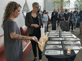University of Regina Women's Centre executive director Jill Arnott, left, and Regina YWCA senior director of community programs Tara Molson, right, light candles at the U of R in memory of the 14 women killed in the École Polytechnique shooting in Montreal on Dec. 6, 1989.