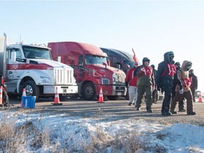 Locked out Unifor workers march on a picket line while semi trucks wait at the Co-op refinery in Regina, Saskatchewan on December 10, 2019.