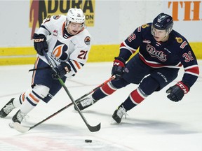 The Kamloops Blazers' Ryan Hughes, left, tries to keep the puck from Robbie Holmes of the Regina Pats during WHL action at the Brandt Centre on Wednesday.