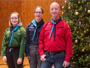 Rachel Vogelsang, Cole Vogelsang and Grant Vogelsang stand next to a Christmas tree at the Lakeview United Church on McCallum Avenue in Regina, Saskatchewan on Dec. 20, 2019. Grant Vogelsang is a Scout leader with the Lakeview Scouts group who helps run a Christmas tree pick-up program with his group to raise money for their camp programs.