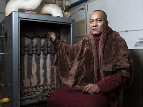 Rev. Uttam Barua sits next to a broken boiler in the basement of the Buddhist Centre of Regina. The ancient boiler malfunctioned on Dec. 12, leaving the building without heat and the organization with a $45,000 replacement cost.