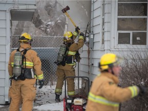 Firefighters work at a house fire in a home on Cameron Street in Regina, Saskatchewan on Dec 31, 2019.