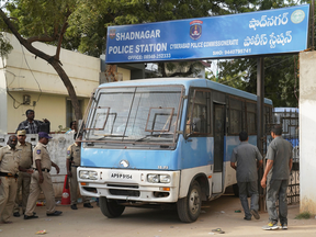 A police van carrying four men accused of the rape and murder of a 27-year-old woman leaves a police station on the outskirts of Hyderabad, India, Nov. 30, 2019.