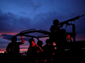 Soldiers assigned to the National Guard keep watch while escorting a caravan of vehicles with relatives and friends arriving for the funerals of slain members of the Mexican-American Mormon families, in Bavispe, Sonora state, Mexico November 6, 2019.