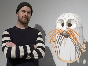 Saskatoon-based artist Todd Gronsdahl poses for a photo with one of his sculptures at the Art Gallery of Regina.
