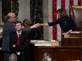 U.S. Speaker of the House Nancy Pelosi (D-CA) shakes hands with House Rules Committee Chairman Rep. Jim McGovern (D-MA) as she presides over the House of Representatives vote on a second article of impeachment against U.S. President Donald Trump, acusing the president of abusing his power and obstructing Congress, inside the House Chamber of the U.S. Capitol in Washington, U.S., December 18, 2019. REUTERS/Jonathan Ernst