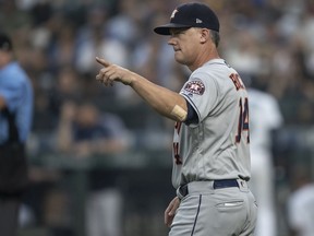 SEATTLE, WA - AUGUST 21: Houston Astros manager AJ Hinch gestures to the bullpen to replace starting pitcher Brad Peacock #41 of the Houston Astros with relief pitcher Framber Valdez #65 of the Houston Astros during the second inning of a game against the Seattle Mariners at Safeco Field on August 21, 2018 in Seattle, Washington.