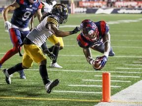Montreal Alouettes William Stanback dives for a touchdown past Hamilton Tiger-Cats Rico Murray during Canadian Football League game in Montreal July 4, 2019.