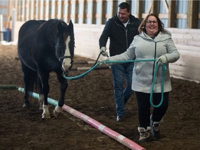 Terri Kot, front, and Keith Olberg walk with horse Journey at the Double T Ranch near Qu'Appelle, Saskatchewan on Jan 10, 2020. Kot and Olberg are participants in an Equine Assisted Learning program at the ranch, which aims to help people overcome trauma through horse therapy.