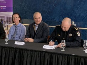 Regina Police Chief Evan Bray signs the Regina Human Service Partnership (RHSP) Community Violence Threat Risk Assessment & Support Protocol as co-chair of the RHSP. Kevin Cameron, executive director of the North American Centre for Threat Assessment and Trauma Response (NACTATR), left, and Riel Bellegarde, president and CEO of Saskatchewan Indian Institute of Technologies, centre, look on after also signing the document.