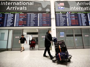 Travellers wear masks at Pearson airport arrivals, shortly after Toronto Public Health received notification of Canada's first presumptive confirmed case of coronavirus, in Toronto, Ontario, Canada January 25, 2020. (Carlos Osorio/Reuters)