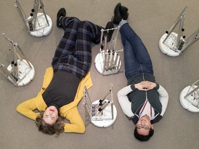 Artist Erin Gee (left) and curator Tak Pham pose for a photo with Gee's piece "Swarming Emotional Pianos," at the MacKenzie Art Gallery.