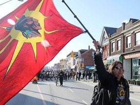 A supporter of the indigenous Wet'suwet'en Nation, carrying a Mohawk Warrior flag, leads a march against British Columbia's Coastal GasLink pipeline, in Toronto, Ontario, Canada February 17, 2020.