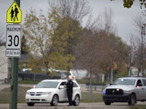 A member of the Regina Police Service issues a ticket in a school zone in Regina on Oct. 8, 2019.