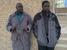 Majok Majok's uncle Acuil Poik (left) and father Agwait Majok stand outside Regina Provincial Court on Feb. 5, 2019.