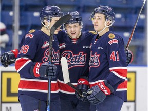 Left to right: Jake Johnson, Riley Krane and Ryker Evans of the Regina Pats celebrate a goal by Krane on Wednesday against the host Saskatoon Blades.
