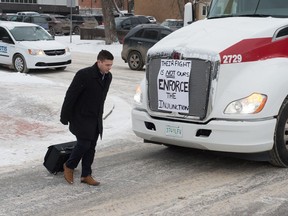 A man crosses the street in front of a Co-op semi truck, which was part of a large convoy on Victoria Avenue in Regina, Saskatchewan on Feb. 6, 2020. BRANDON HARDER/ Regina Leader-Post