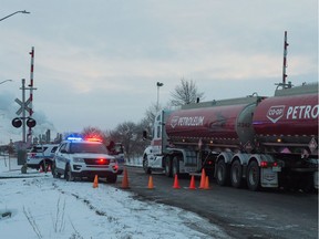 Regina Police Service officers allow a Co-op fuel truck to pass by their controlled checkpoint at the intersection of Winnipeg Street and 9th Avenue North in Regina, Saskatchewan on Feb. 7, 2020.