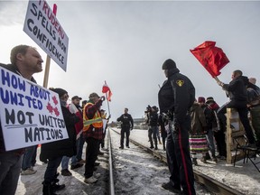 Saskatoon police monitor as people confront a group gathered in solidarity with the Wet'suwet'en hereditary chiefs, setting up a demonstration along a section of railway in between 20th Street West and 21st Street West on Avenue I in Saskatoon on Feb. 22, 2020