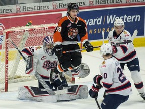 The Medicine Hat Tigers'  Jonathan Brinkman jumps to avoid a shot in front of Regina Pats goalie Donovan Buskey.