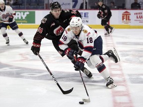 Regina Pats forward Cole Dubinsky tries to get past Calder Anderson of the Moose Jaw Warriors in WHL action at the Brandt Centre on Tuesday.