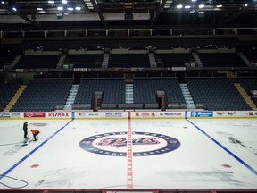 Evraz Place employees remove logos from the ice surface at the Brandt Centre in Regina on Tuesday.