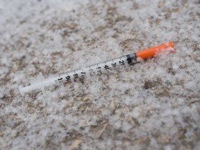 A recently discarded syringe lays covered by freshly fallen snow in an alley in Regina, Saskatchewan on Mar 18, 2020.