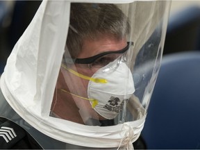 Staff Sgt. Brad Walter demonstrates part of the fitment process for respiratory protection masks being undertaken by the Regina Police Service on March 19, 2020. The masks will be used to protect front line officers against the COVID-19 virus in instances where they need to come into contact with an individual who may have the virus. The hood worn by Walter is used during fitment only.