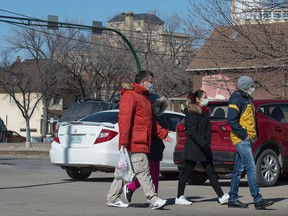 A group of people wearing masks leave the Shopper's Drug Mart location on Broad Street in Regina, Saskatchewan on Mar. 19, 2020.