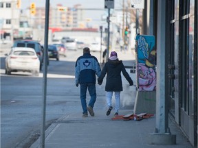 Two people hold hands while walking on Broad Street on March 20.