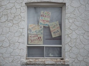 A home in Regina's Heritage neighbourhood displays signs in a window offering thanks for doctors and nurses during the COVID-19 pandemic in Regina, Saskatchewan on March 24, 2020.