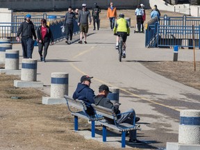 People flood the walking path along the edge of  Wascana Lake on a warm afternoon in Regina, Saskatchewan on March 28, 2020.
