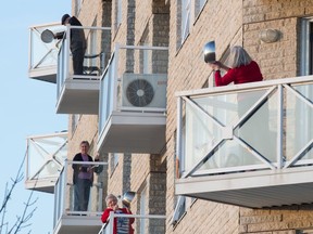 Residents at the Broadway Terrace seniors home stand out on their balconies to participate in a group noise-making effort, as an act of appreciation for the staff that help them.