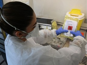 A biologist stores samples at a COVID-19 screening-drive in Montpellier, south-western France, on March 27, 2020, as the country is under lockdown to stop the spread of the Covid-19 pandemic caused by the novel coronavirus. (Photo by Pascal GUYOT / AFP)