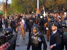 Police officers gather to stop the men from various religious groups who protest near the site of an Aurat March, Urdu for Women's March, in Islamabad, Pakistan, March 8, 2020.