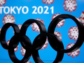 A 3D printed Olympics logo is seen in front of displayed "Tokyo 2021" words in this illustration taken March 24, 2020.