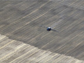 A farmer works in the field north of Regina on June 08, 2012.