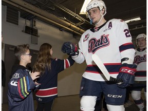 Austin Wagman prepares to give defenceman Kyle Walker a high-five as the Regina Pats walk out on to the ice before facing off against the Moose Jaw Warriors in Regina on March 3 at the Brandt Centre.
