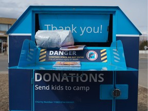 Items hang out of the mouth of a clothing donation bin near a 7-Eleven Store on Montague Street in Regina, Saskatchewan on April 7, 2020. The Diabetes Canada bins are becoming overfull, as pickups have stopped due to the COVID-19 pandemic.