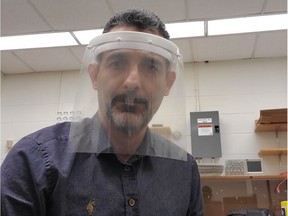Alireza (Mehran) Talebitaher, a senior post-doctoral researcher at the University of Regina's department of physics, models one of the prototype face shields made by the department's 3D printer. (Photo courtesy University of Regina.)