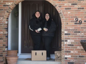 Robyn Kouros, right, and her daughter Ava make bagged lunches to donate to Carmichael Outreach in Regina on Thursday, April 9, 2020.