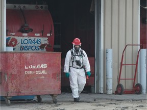 A person wearing protective clothing exits the Loraas Disposal Services building on McLeod Street in Regina, Saskatchewan on April 20, 2020. A fire damaged the building on April 19 and The Regina Fire Department's investigative team was looking into the cause.