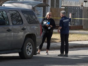 A coroner speaks to a police officer at the scene of a death investigation on the 1000 block of Princess Street in Regina, Saskatchewan on April 23, 2020.