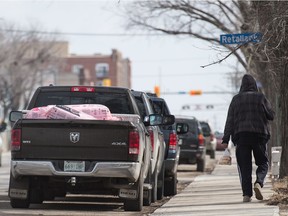 A man carries a bag of buns down Dewdney Avenue in Regina, Saskatchewan on April 7, 2020.