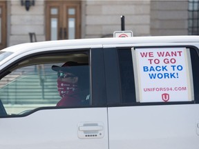 REGINA, SASK : April 29, 2020  -- A Unifor member drives an automobile past the Saskatchewan Legislative Building as part of a "vehicle rally" for the union taking place in Regina, Saskatchewan on April 29, 2020. The rally was in support of Unifor Local 594, the members of which are currently locked out of the Co-op Refinery Complex. BRANDON HARDER/ Regina Leader-Post