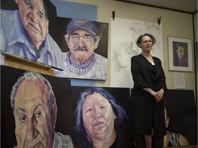 Carol Wylie stands in front of her paintings during an Art show and sale run by 11 female Saskatoon artists with more than 250 years of collective experience in Saskatoon on Sunday, November 25, 2018.