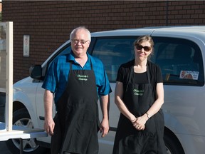 Bernie Dombowsky, left, and wife Charlotte Dombowsky, of Charlotte's Catering out of Moose Jaw stand behind the St. James United Church in Regina, Saskatchewan on May 2, 2020. The pair operate a drive-through food pick-up service there. BRANDON HARDER/ Regina Leader-Post