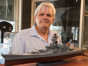 Bob Griffin stands behind a model ship he built in the Redline Hobby shop on Albert Street in Regina.