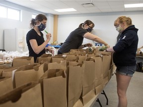 Adrea Propp, from left,  and Kerri Doidge and Rebecca Fercho prepare online orders for The Regina Farmers Market in Regina on Saturday, May 9, 2020.  The Regina Farmers' Market has moved to an online ordering system. Patrons with orders can do curbside pickup on Saturday at Douglas Park or opt for home delivery.
