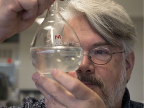 University of Regina biology professor Peter Leavitt looks through a volometric flask in the Environmental Quality Analysis Laboratory located in the Research and Innovation Centre building.